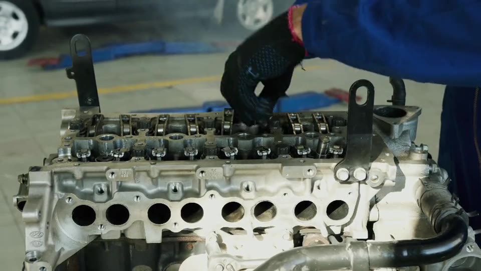 Technician repairing an exposed car engine cylinder head