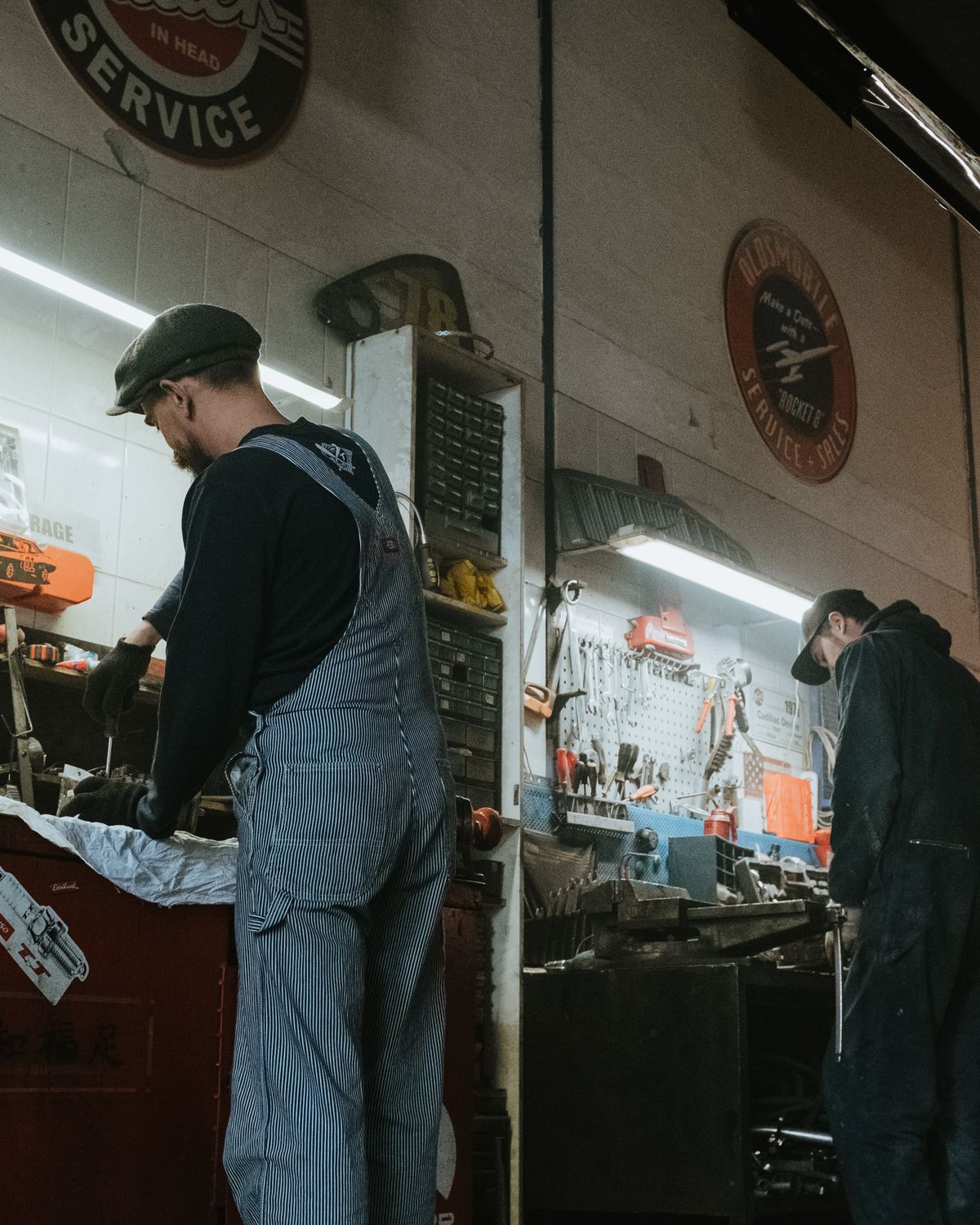 Professional mechanics carrying out routine vehicle maintenance in a garage