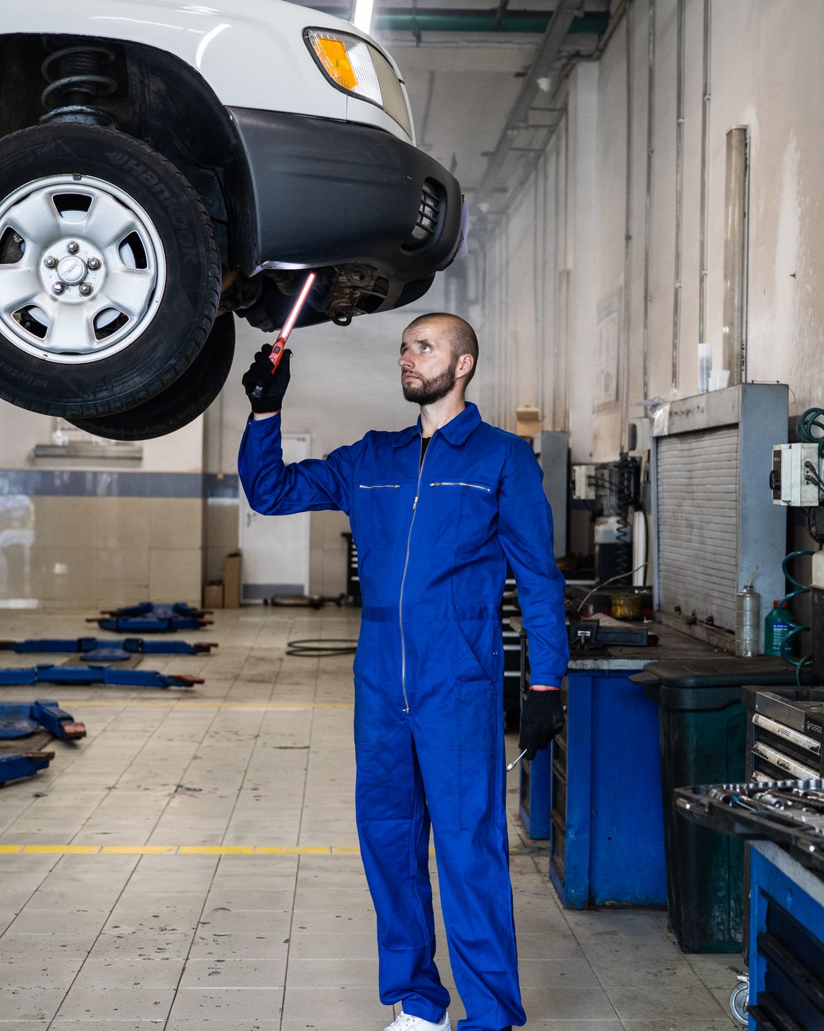 Mechanic inspecting vehicle systems in a workshop